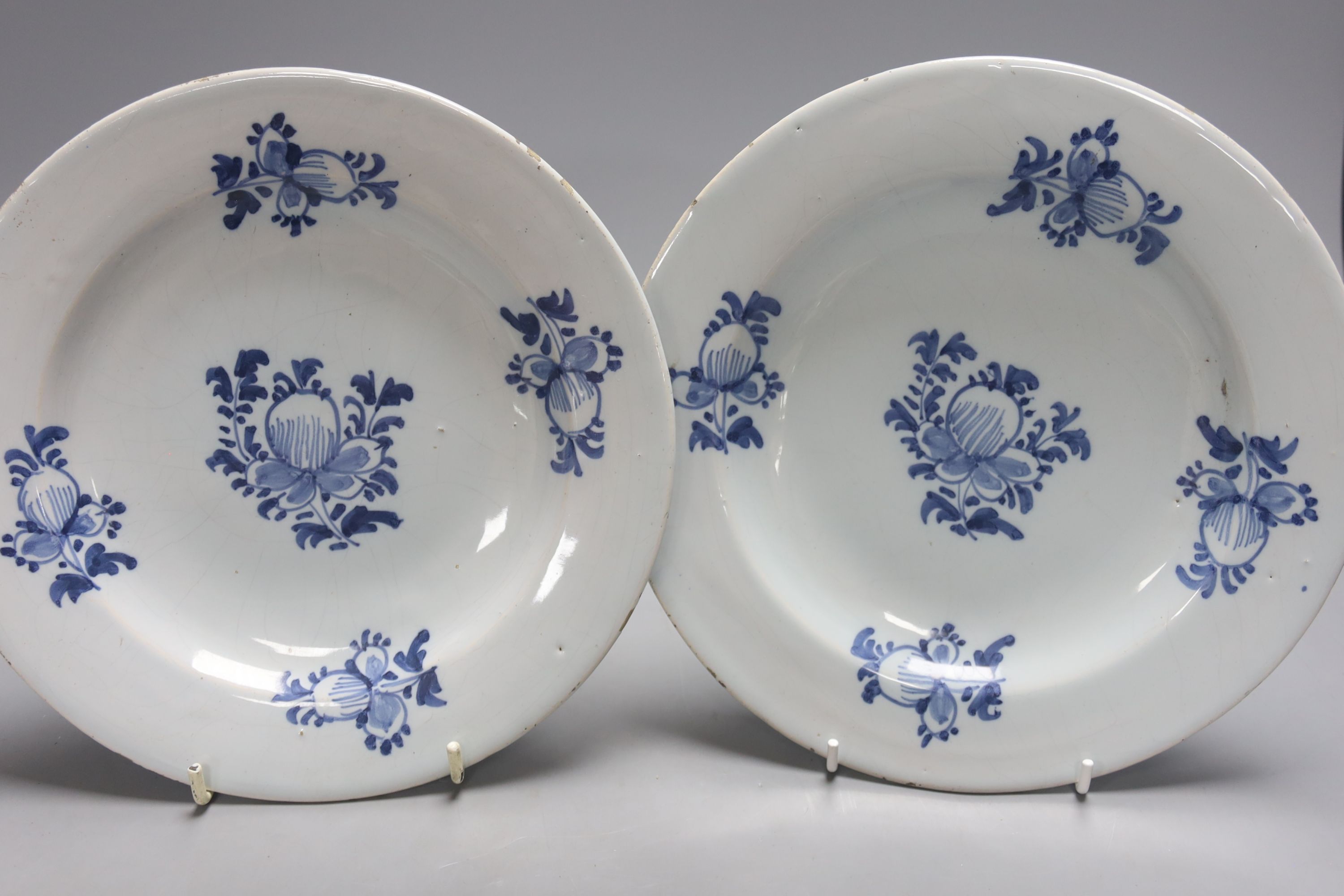 A mid-18th century Dutch Delft flower and fence-decorated blue and white baluster vase, a similar plate and a pair of English delft plates, H 20cm (vase)